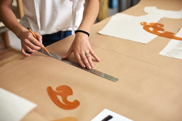 Mãos de designer femininas fazendo desenhos de linhas em papelão