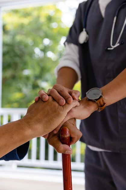 Foto mãos de diversos médicos do sexo masculino e doentes do sexo masculino idosos segurando uma bengala em casa. serviços médicos, check-up, visita domiciliar, cuidados de saúde, bem-estar e estilo de vida dos idosos, inalterados.