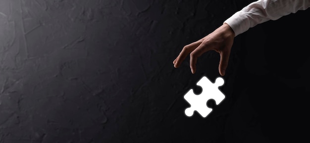 Mãos de empresário conectando peças do puzzle que representam a fusão de duas empresas ou conceito de joint venture, parceria, fusões e aquisição.