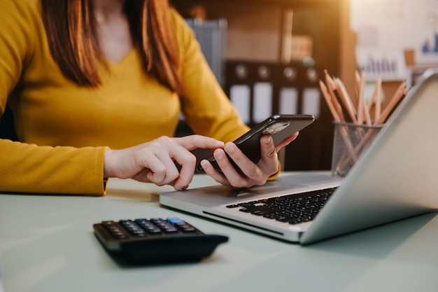 Mãos de empresário trabalhando com finanças sobre laptop de custo com tablet smartphone e escritório de calculadora