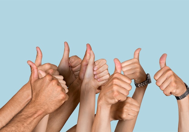 Mãos de grupo de pessoas mostrando sinais de positivo no fundo