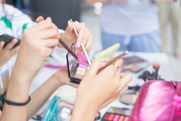 Mãos, de, grupo, meninas, segurando, escova maquiagem, e, paleta, para, maquilagem, conceito beleza