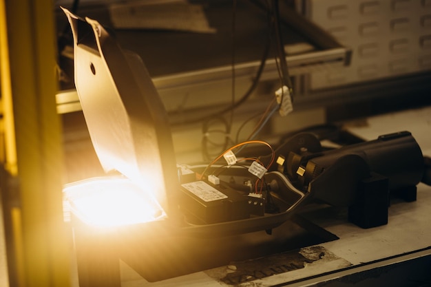 Mãos de homem africano com chave de fenda elétrica trabalhando com sceme elétrico para lâmpadas LED Ele está sentado em sua mesa de trabalho vestindo uniforme