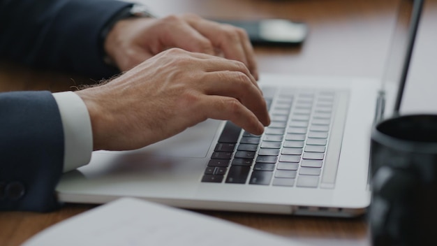 Mãos de homem digitando teclado de laptop na mesa fechando empresário usando computador