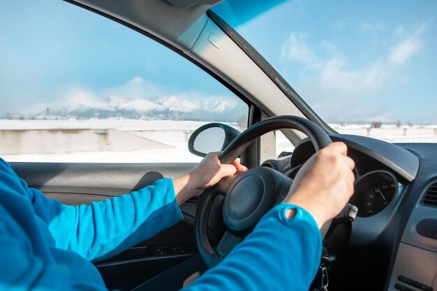 Mãos de homem na viagem de inverno do volante