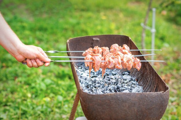 Mãos de homem prepara carne de churrasco