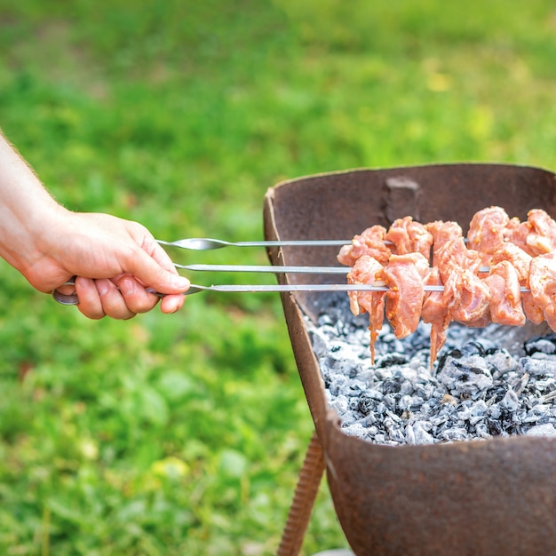 Mãos de homem prepara carne de churrasco