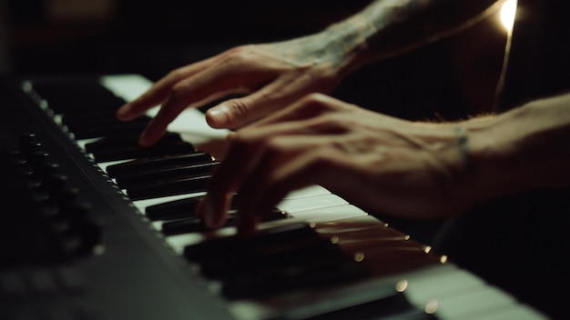 Mãos de homem pressionando teclas no piano no estúdio de gravação Músico fazendo música