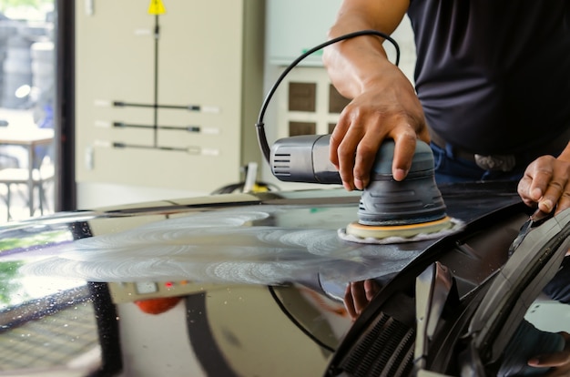 Mãos de homem segurando a ferramenta de trabalho polem o carro