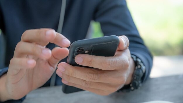 Mãos de homem segurando um smartphone