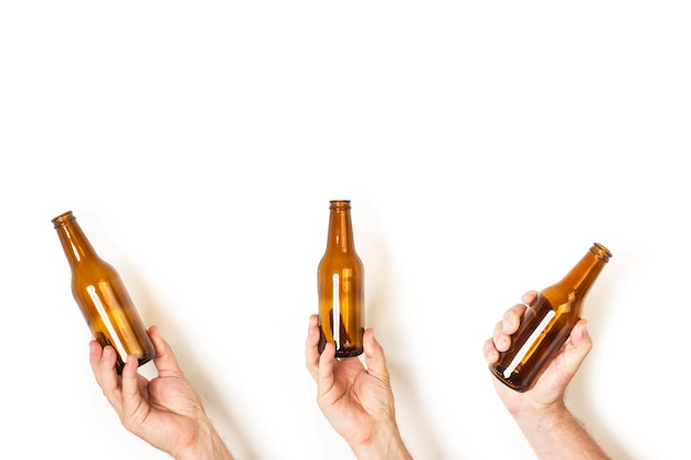 Mãos de homem segurando uma garrafa vazia de cerveja em um fundo branco