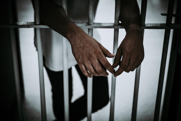 Mãos de homens desesperados para pegar a prisão de ferro conceito de prisioneiro povo da tailândiaEsperança para ser livre