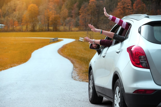 Mãos de homens e garotas olhando pela janela de um carro em um fundo de montanhas. Viagem de verão.