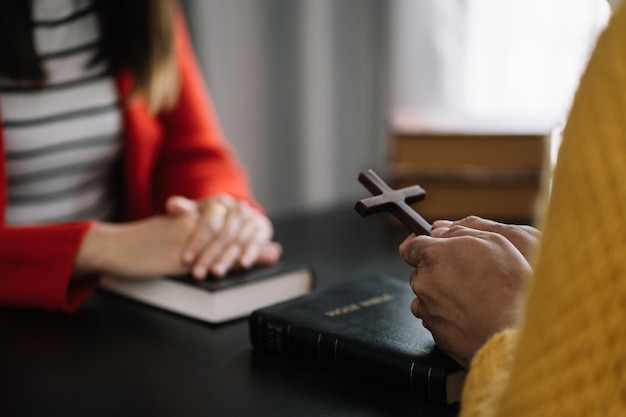 Mãos de homens e mulheres asiáticos orando a deus com a bíblia Ore pela bênção de deus Crenças religiosas Oração de crise de vida cristã a deus