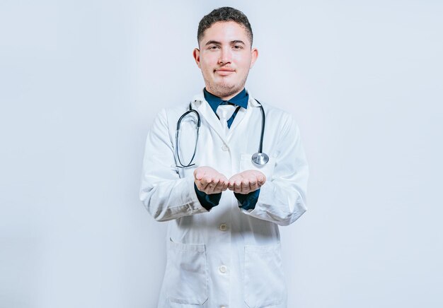 Mãos de jovem médico apresentando algo de mãos vazias médico com as mãos juntas e vazio médico segurando algo em suas mãos isolado