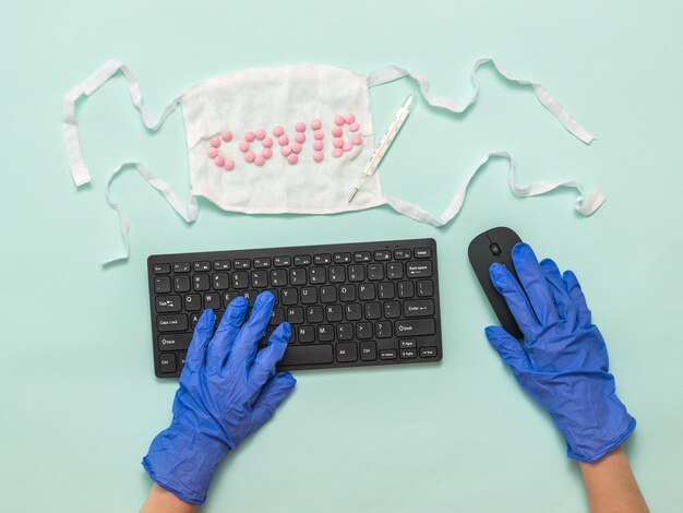 Mãos de luvas azuis com teclado e mouse sem fio Prevenção da propagação do coronavírus