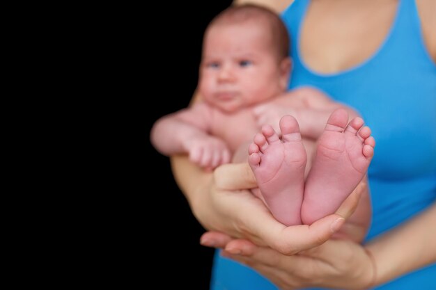 Foto mãos de mãe segurando bebê recém-nascido