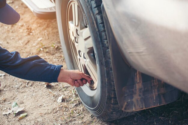 Mãos de mecânico verificando pneus de carro ao ar livre serviço no local garagem automática para serviços de centro móvel automotivo Reparo de oficina técnico verificando pneus serviço de veículos motorizados mãos mecânicas