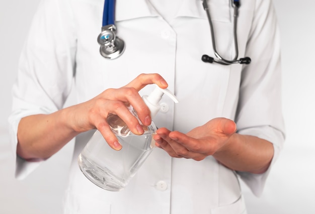 Mãos de médico aplicando desinfetante antibacteriano e lavando as mãos.