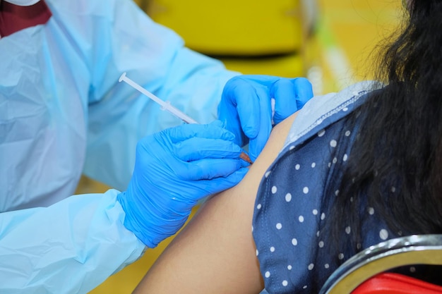 Mãos de médico que estão vacinando no braço das pessoas para criar infecção de imunidade covid19