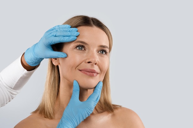 Foto mãos de médico usando luvas desenhando segurando a cabeça de uma paciente feminina