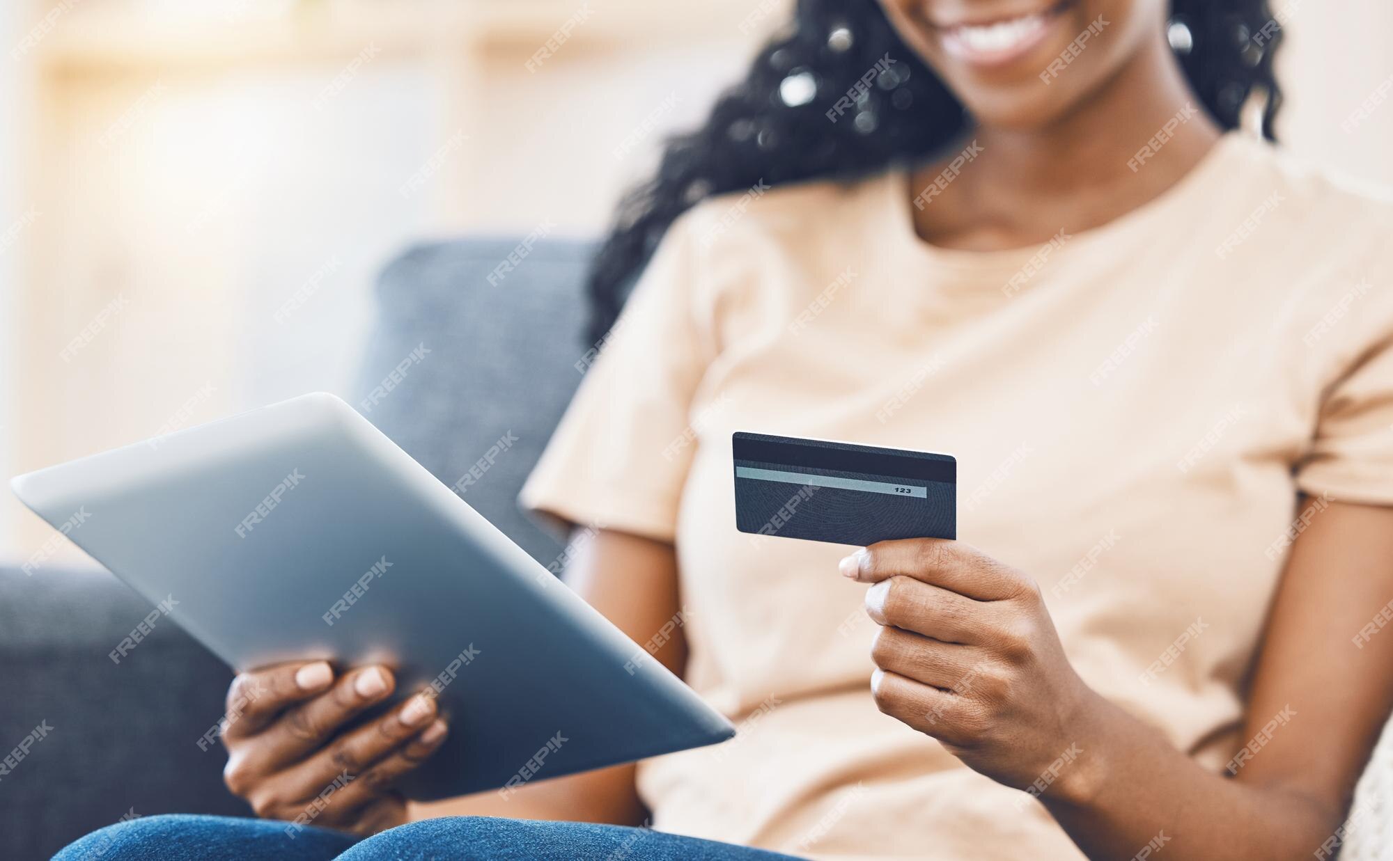 close-up de garota negra segurar o cartão de crédito do banco e digitar no  laptop