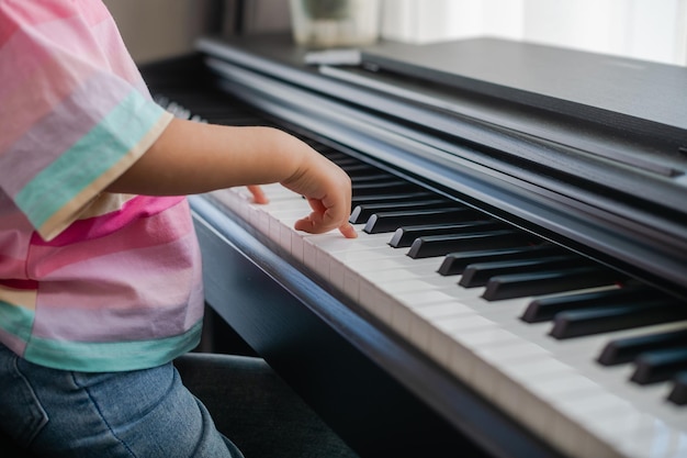 Mãos de menina tocando piano foco seletivo