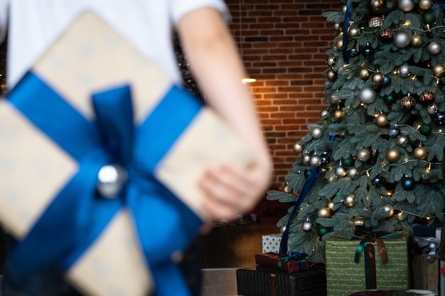 Mãos de menino segura presente de Natal ou caixa de presente decorada de ano novo. Alegria paz amor