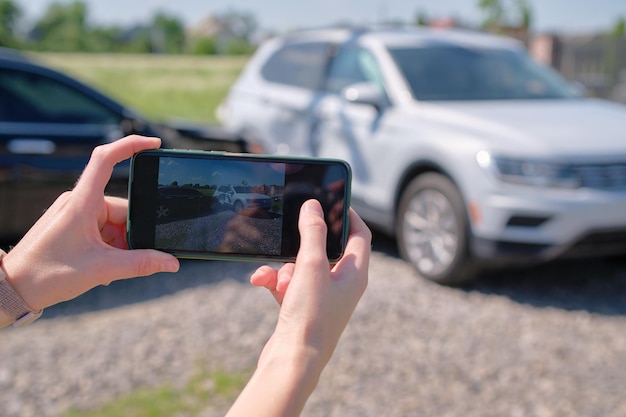 Mãos de motorista tirando foto na câmera do celular após colisão do veículo na rua para serviço de emergência após acidente de carro Conceito de segurança e seguro viário