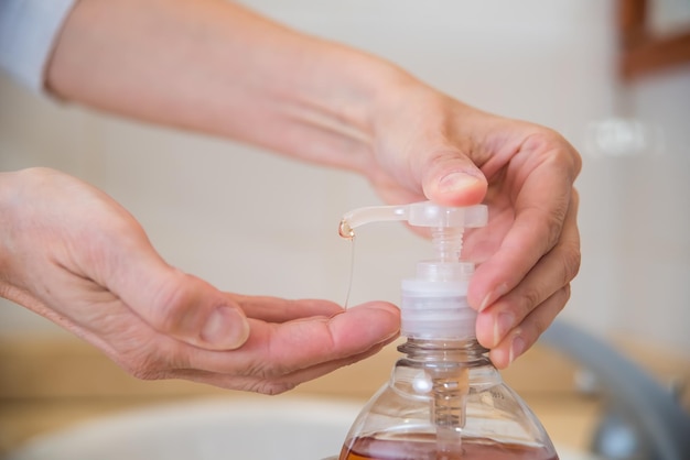 Mãos de mulher adulta colocando sabonete líquido lavando as mãos higiene saúde limpeza limpeza