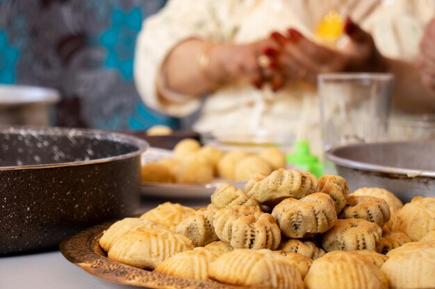 Mãos de mulher árabe fazendo biscoitos de doces eid e mamoul