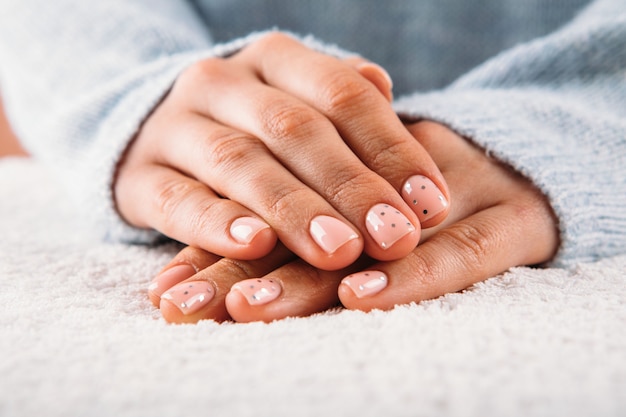 Mãos de mulher bonita com unhas cor de rosa em fundo branco. Verniz para unhas na cor rosa. Manicure, pedicure conceito de salão de beleza.