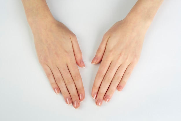 Mãos de mulher com manicure francesa