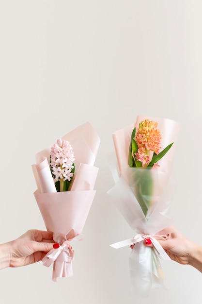 Mãos de mulher com manicure segurando flores da primavera.