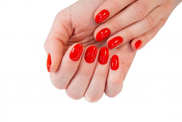 Mãos de mulher com unhas vermelhas.