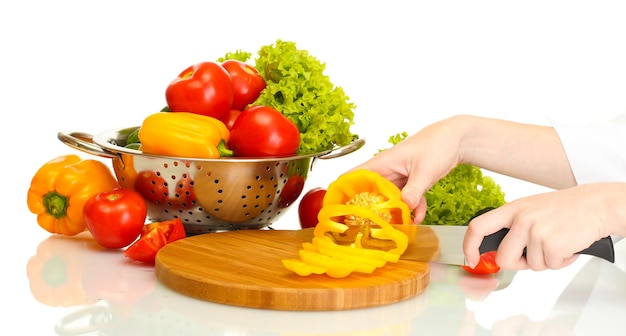 mãos de mulher cortando legumes no quadro negro da cozinha