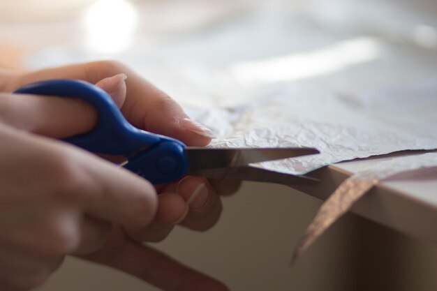 Foto mãos de mulher cortando material de papel com tesoura