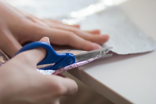 Foto mãos de mulher cortando material de papel com tesoura