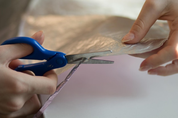 Foto mãos de mulher cortando material de papel com tesoura