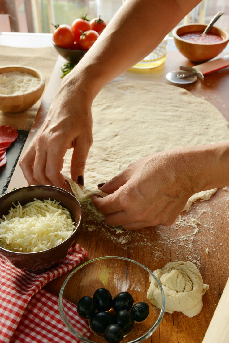Foto mãos de mulher cozinhar pizza em casa, adicionando todos os ingredientes
