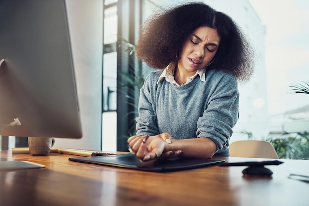 Mãos de mulher de negócios e computador com dor no pulso sobrecarregado ou inflamação das articulações na mesa do escritório Mão de uma funcionária que sofre de síndrome do túnel do carpo, dor ou desconforto no local de trabalho