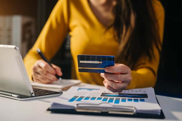 Mãos de mulher de negócios usando smartphone e segurando um cartão de crédito com diagrama de efeito de camada digital como conceito de compra online