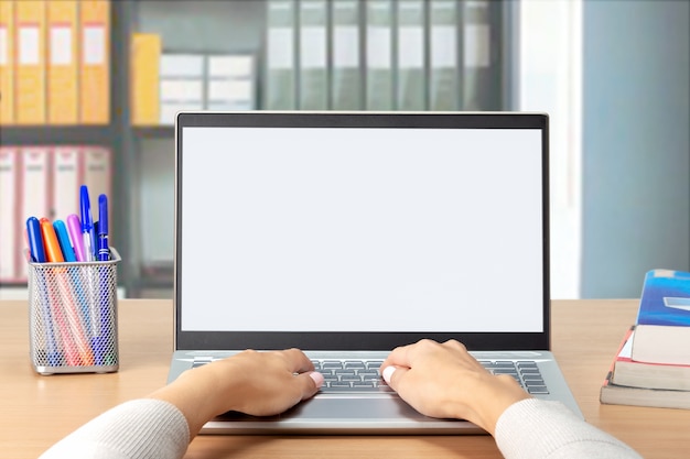 Mãos de mulher digitando no computador laptop com tela branca em branco no escritório. Trabalho de estudo do curso de treinamento à distância de e-learning do aluno em home office.