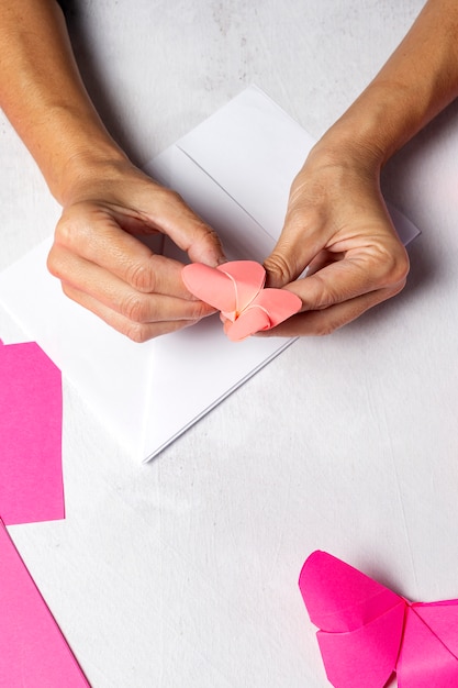 Mãos de mulher fazendo animais de origami sem papel