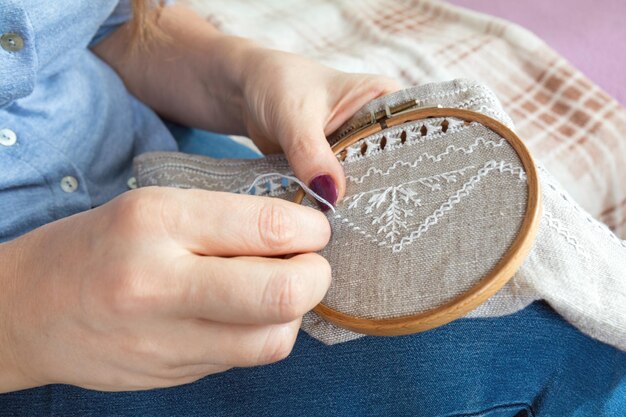 Mãos de mulher fazendo bordados abertos em linho caseiro Fechar Colorir e processar fotos