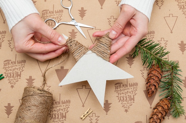 Mãos de mulher fazendo um enfeite de natal