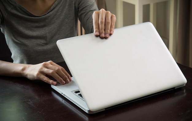 Foto mãos de mulher fechar um laptop em casa na mão de foco de tempo de dia