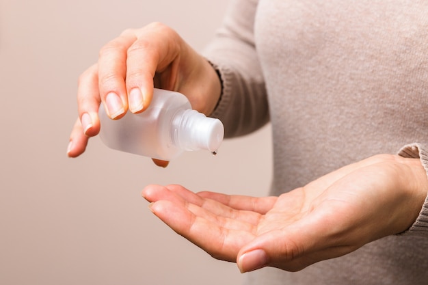 Mãos de mulher limpa closeup usando desinfetante para desinfetar as mãos dela. corrigir ações de higiene