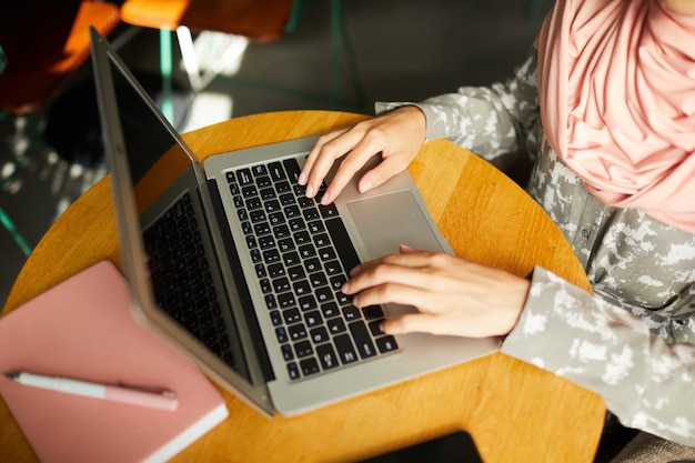 Mãos de mulher muçulmana trabalhando no laptop