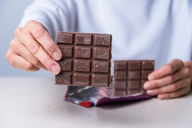 Mãos de mulher oferecendo um chocolatexA